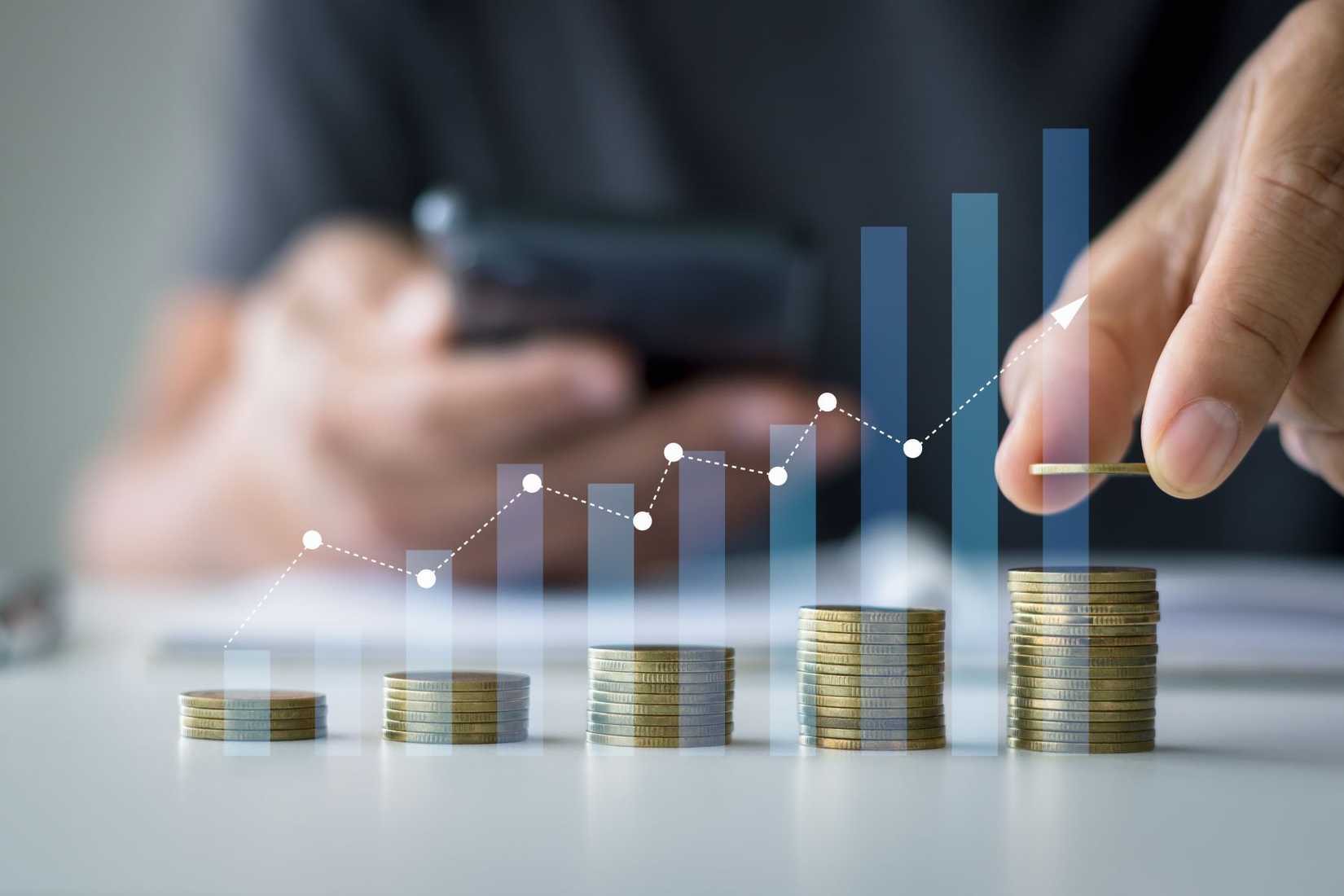 a photo of hands making progressively taller stacks of coins with some graphics overlaid
